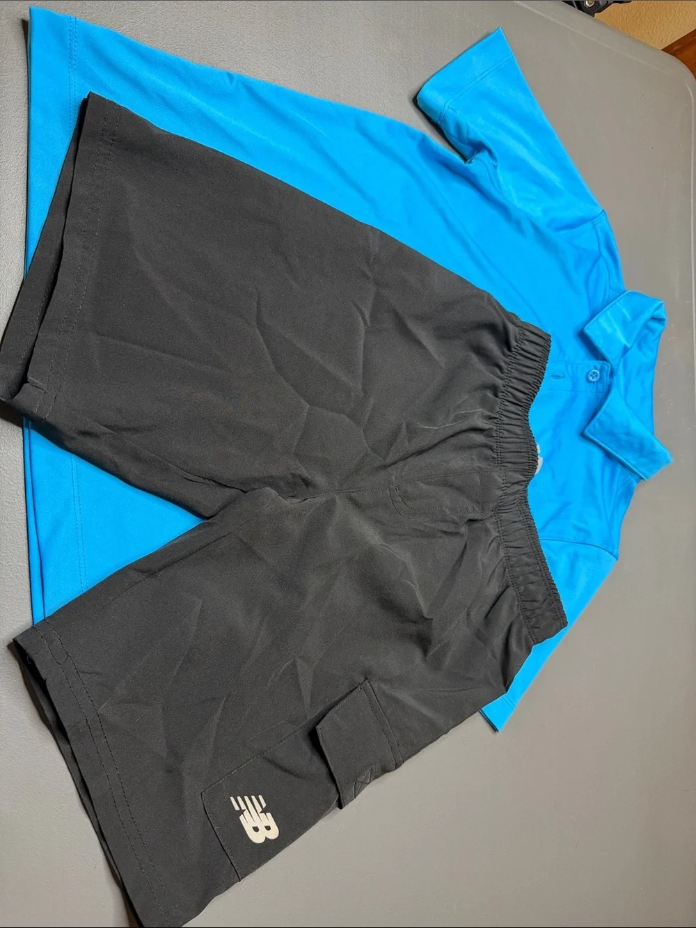 Kid’s New Balance Bright Blue Polo and Black Athletic Shorts Set. Size: 8